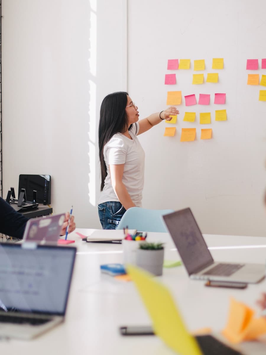 A strategist arranging sticky notes on a campaign planning wall