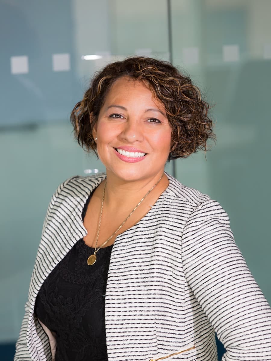 A consultant smiling in a glass-walled office