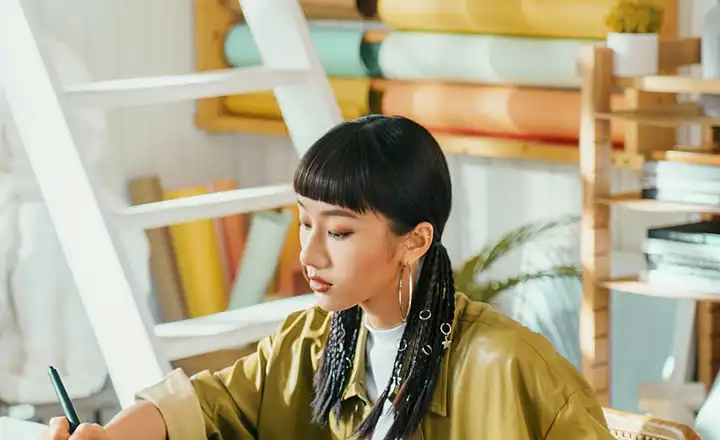 A designer drawing on a pen display in a bright studio